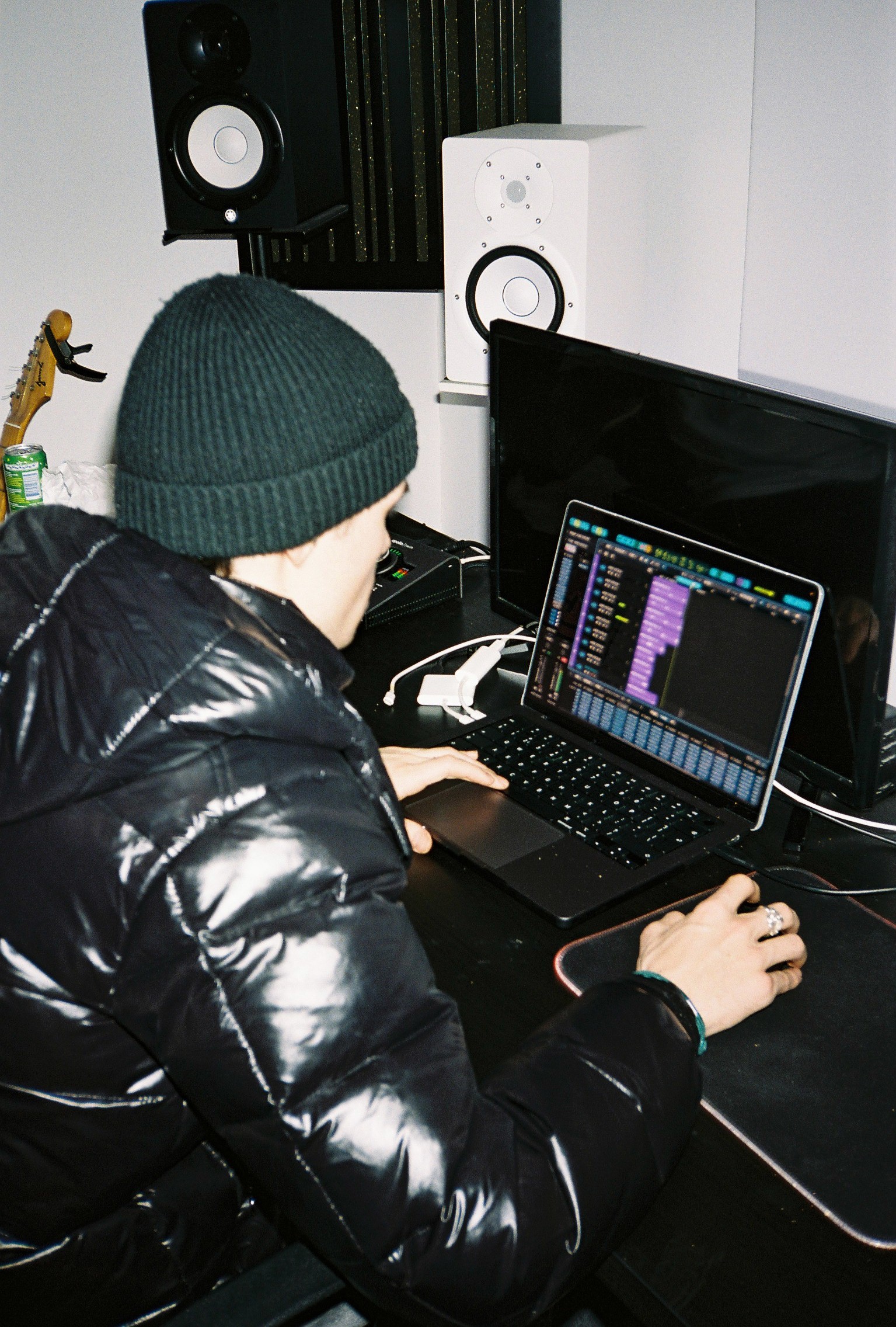Valentino Hu working on a laptop in a music studio.