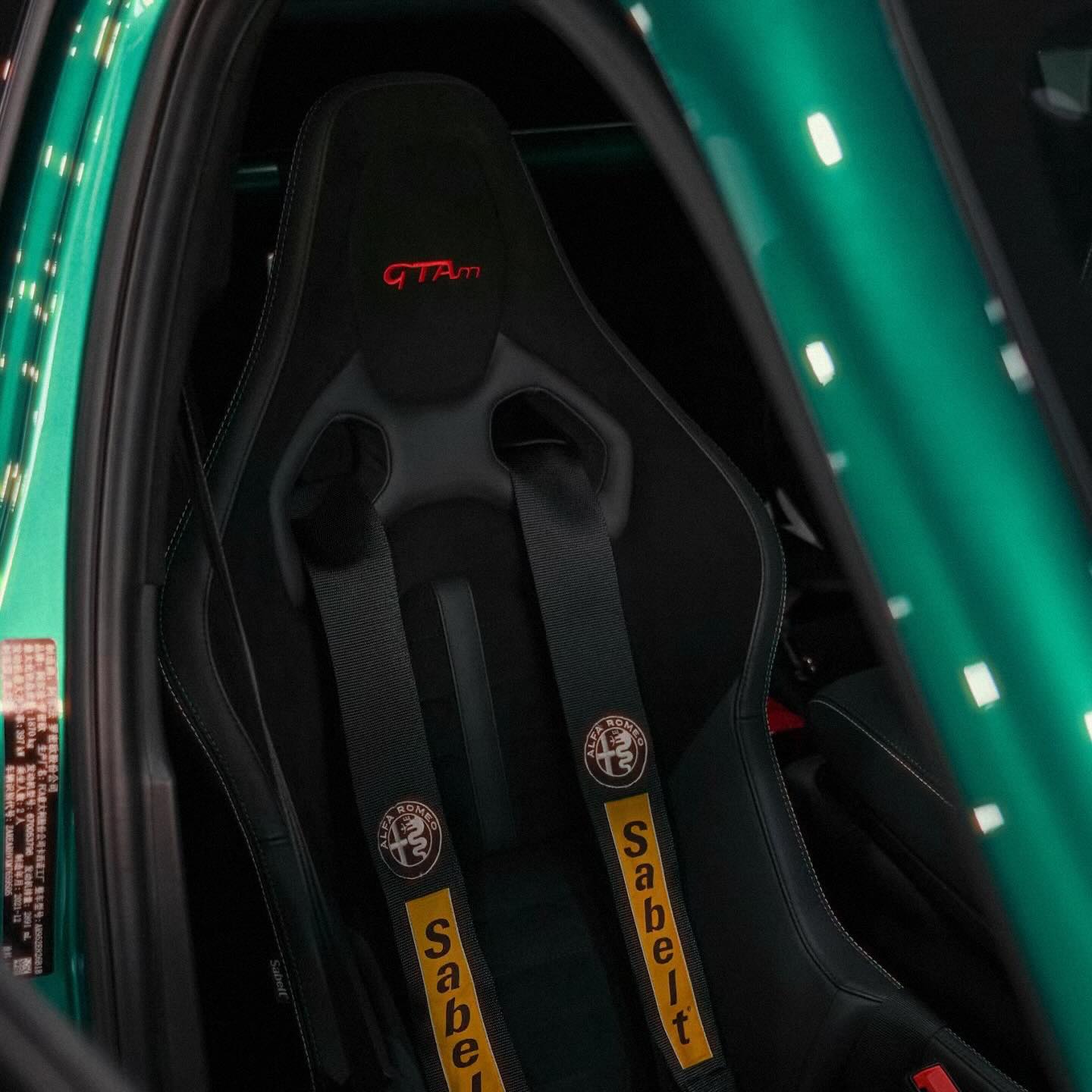 绿色 Alfa Romeo 内的赛车座椅与安全带