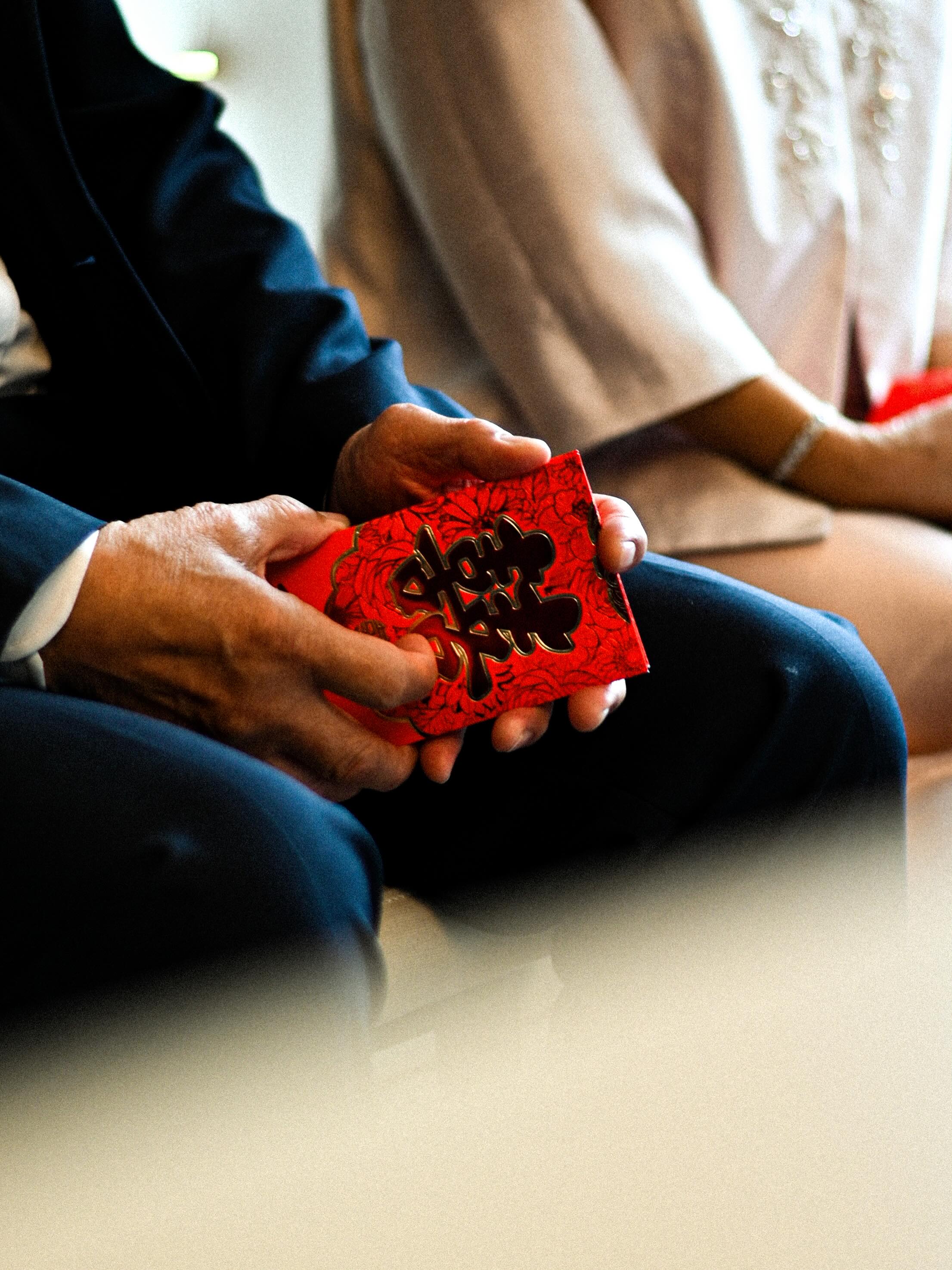 Handen houden een rood kopje vast tijdens de theeceremonie